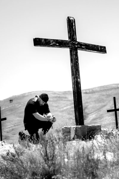 Daily Devotion - Praying with Jesus - Praying in Secret - Man praying alone by a cross
