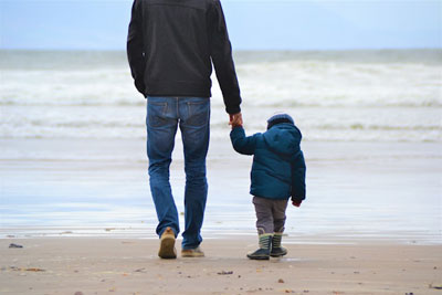 The Other Six - Faith Lutheran Church, Wesley Chapel, FL - Father holding son's hand on the beach