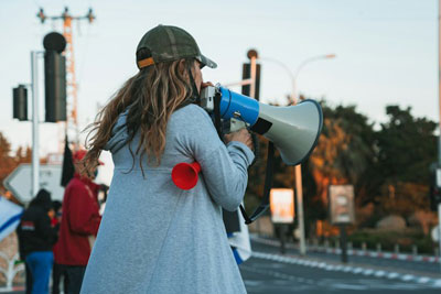 Daily Devotion - Faith Lutheran Church, Wesley Chapel, FL - Woman on a street corner with a bullhorn